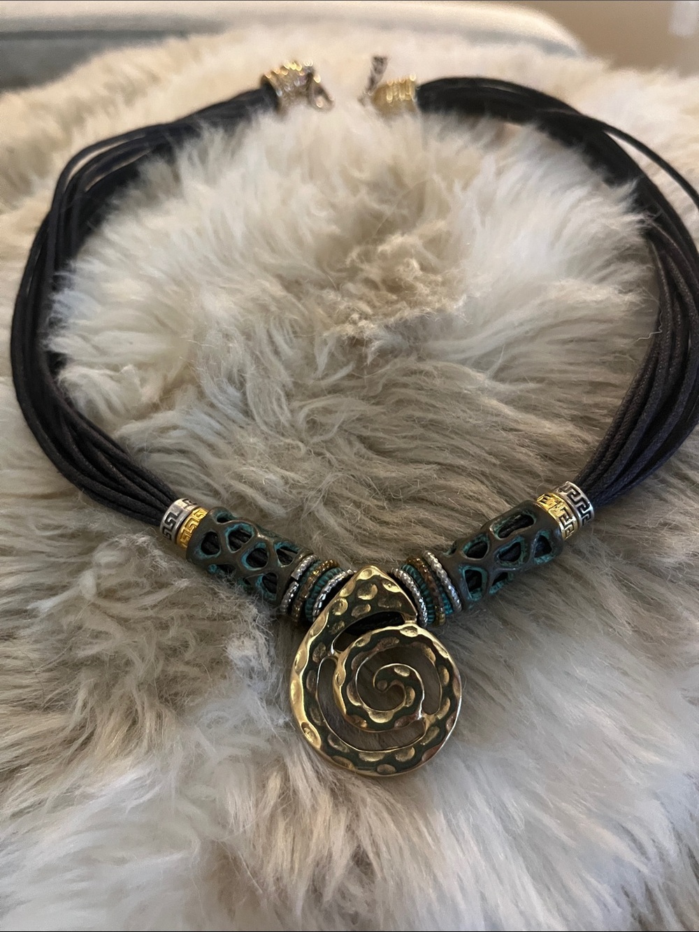 Gold Spiral Pendant Necklace with Teal Accents on green/gray Cord
